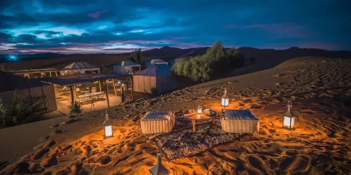 A luxury tented camp in the Sahara at dusk